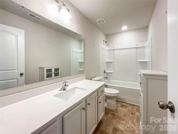 a bathroom with a tub sink and mirror