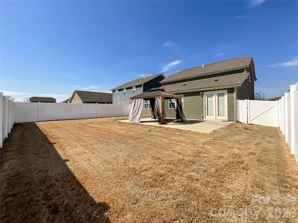 a backyard of a house with table and chairs and wooden floor
