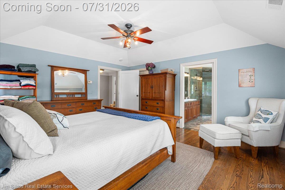 637 Washington Road Grosse Pointe, MI 48230 - Photo 23 of 40 Bedroom featuring a vaulted ceiling with a ceiling fan, wood-finish flooring, and a doorway to a bathroom with a glass-enclosed shower