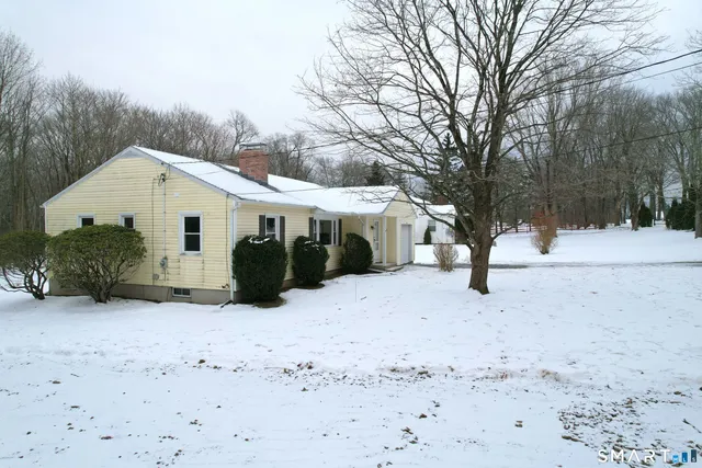 a view of a house with a yard covered in snow