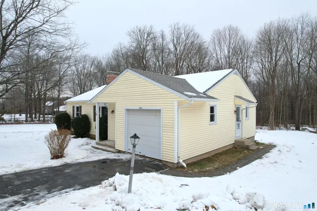 a view of a white house with a yard covered in snow