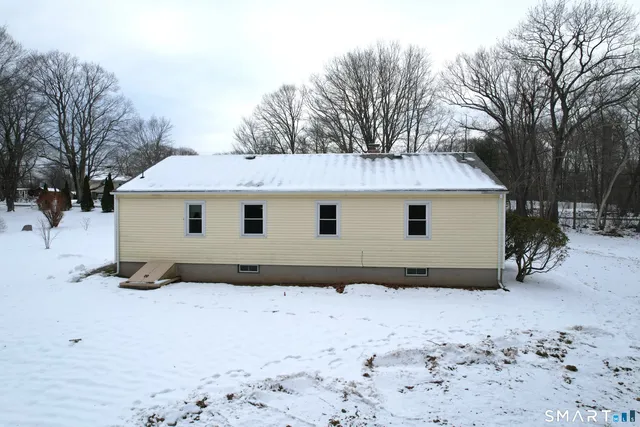 a view of a house with a yard covered in snow