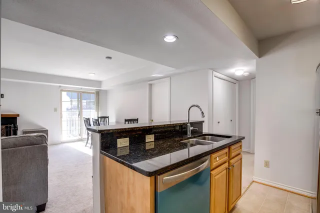 a kitchen with granite countertop a stove and white cabinets