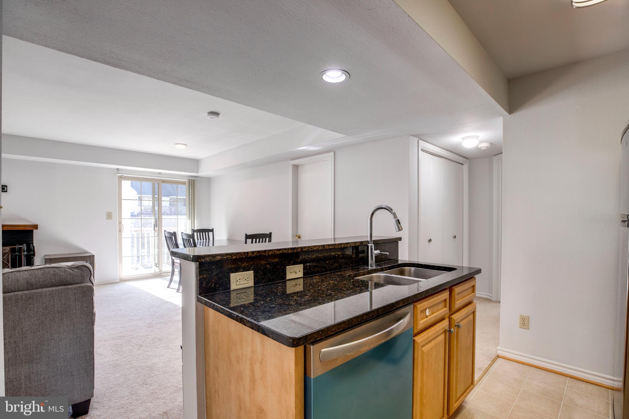 12154 Penderview Terrace, Unit 1231 Fairfax, VA 22033 - Photo 12 of 25 a kitchen with granite countertop a stove and white cabinets