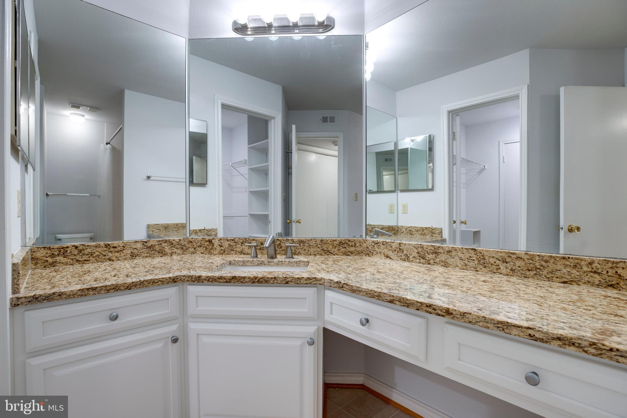 12154 Penderview Terrace, Unit 1231 Fairfax, VA 22033 - Photo 17 of 25 a bathroom with a granite countertop sink and a mirror