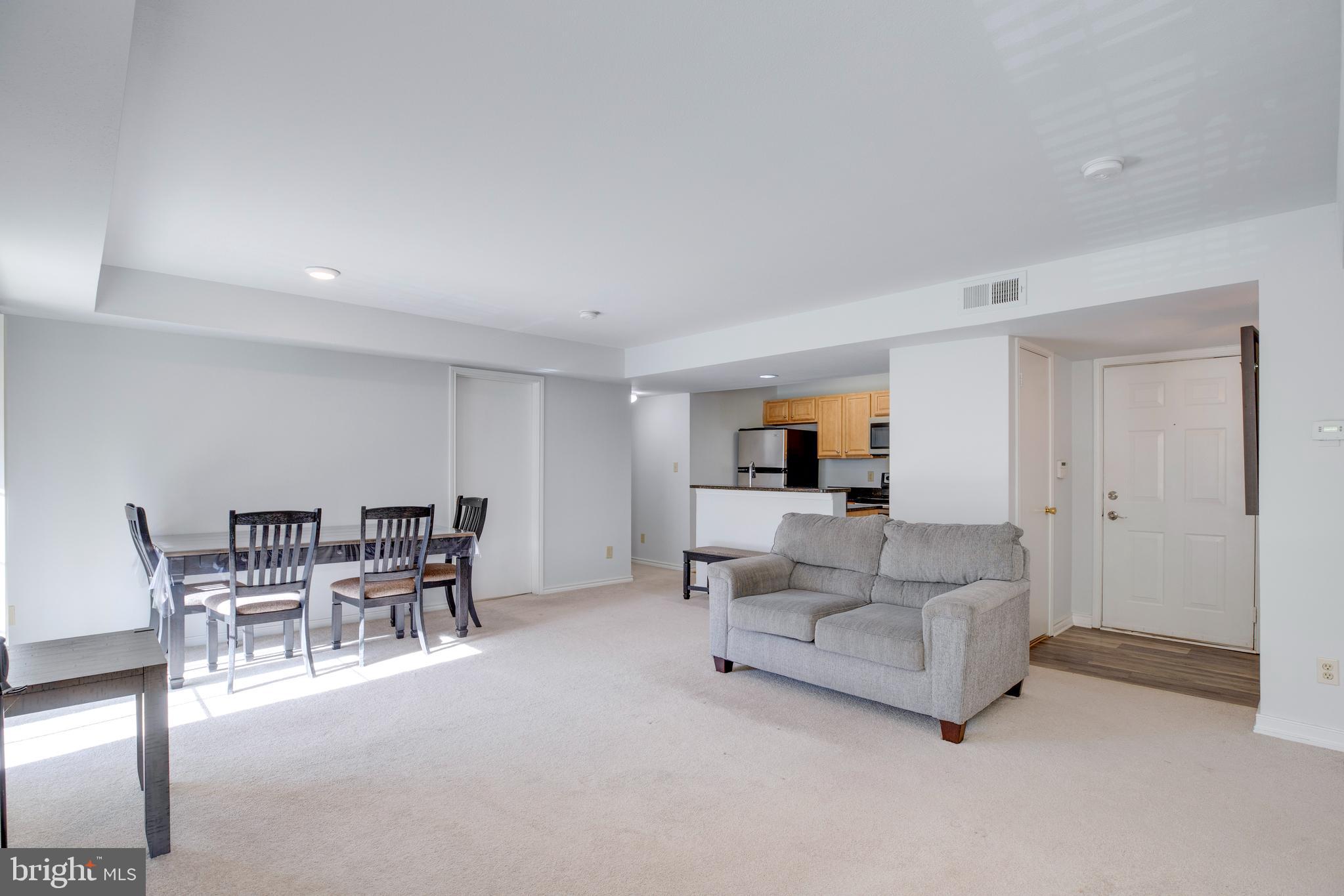 12154 Penderview Terrace, Unit 1231 Fairfax, VA 22033 - Photo 4 of 25 a living room with furniture and a dining table with kitchen view