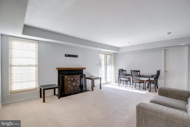 a living room with furniture a fireplace and a window