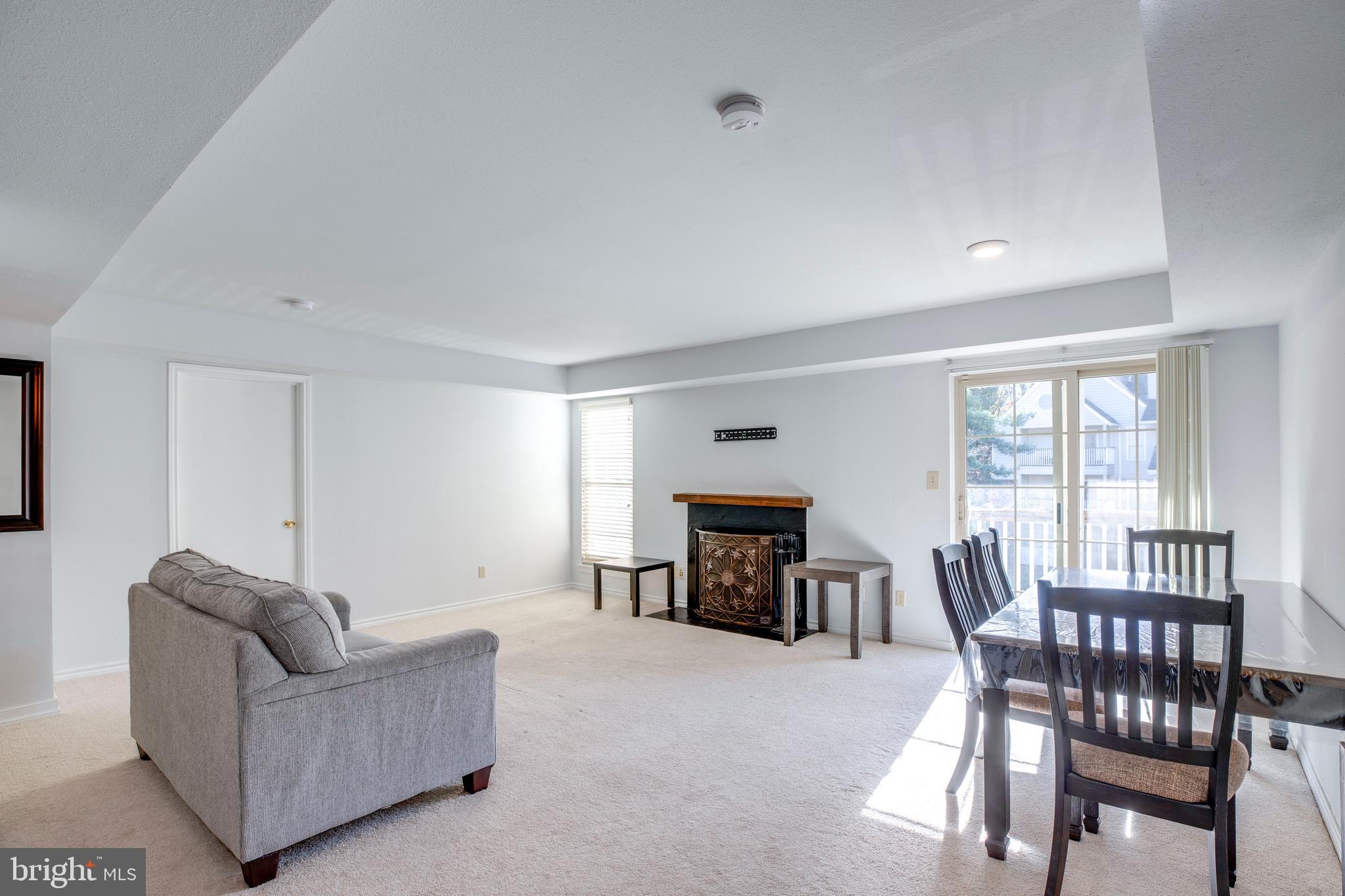 12154 Penderview Terrace, Unit 1231 Fairfax, VA 22033 - Photo 7 of 25 a living room with furniture and a dining table with fireplace