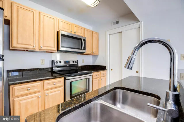 a kitchen with granite countertop a sink and a stove top oven