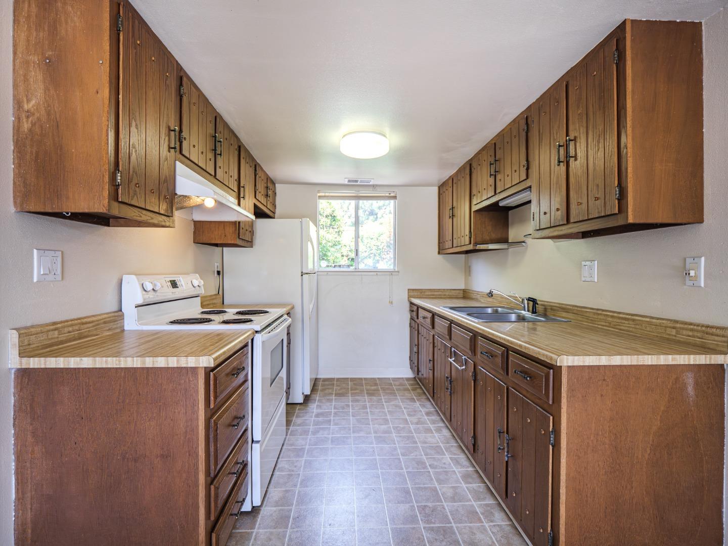 450 Spruce Circle Watsonville, CA 95076 - Photo 21 of 30 a kitchen with stainless steel appliances granite countertop a stove a sink dishwasher and a refrigerator with wooden cabinets