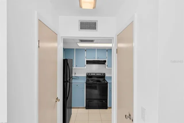 a kitchen with a refrigerator and a stove top oven