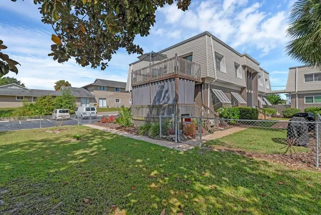 a view of a big house with a big yard and large trees