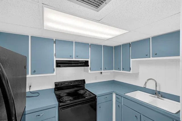 a kitchen with a sink stove and refrigerator