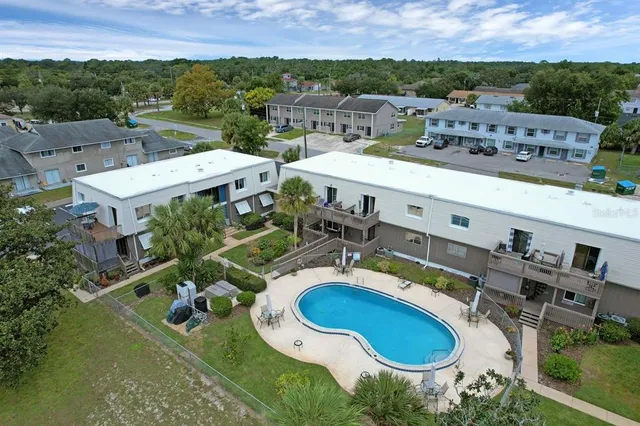 an aerial view of residential houses with outdoor space and parking