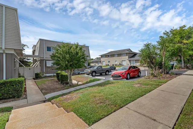a front view of a house with a garden and car parked