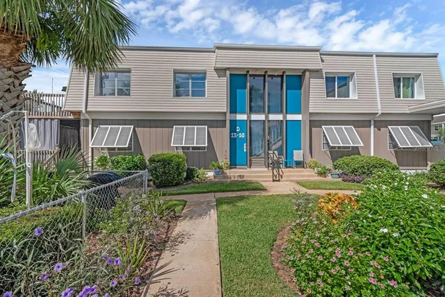 front view of house with a yard and potted plants