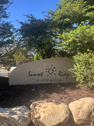 1132 Sunset Dunes Way Draper, UT 84020 - Photo 34 of 35 Stone welcome sign with "Sunset Ridge at South Mountain" inscription, surrounded by natural landscaping