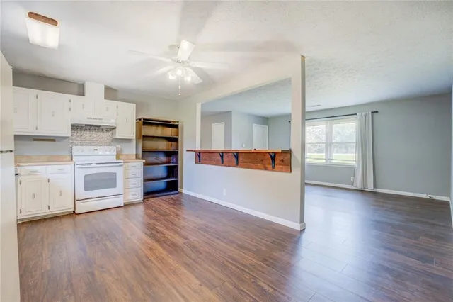 a view of a kitchen with wooden floor and electronic appliances