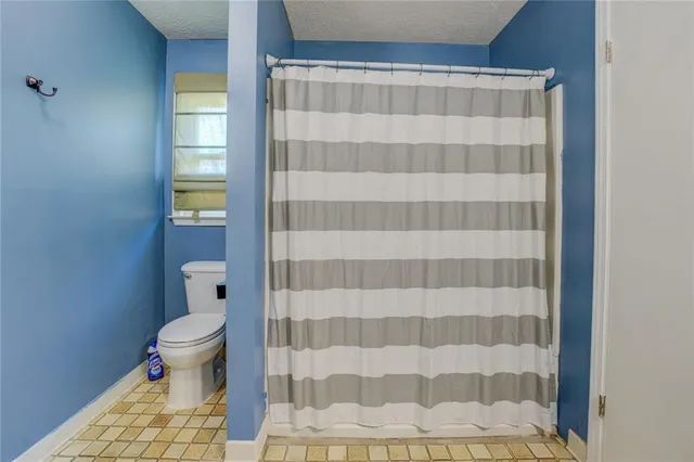 a bathroom with a toilet and a shower