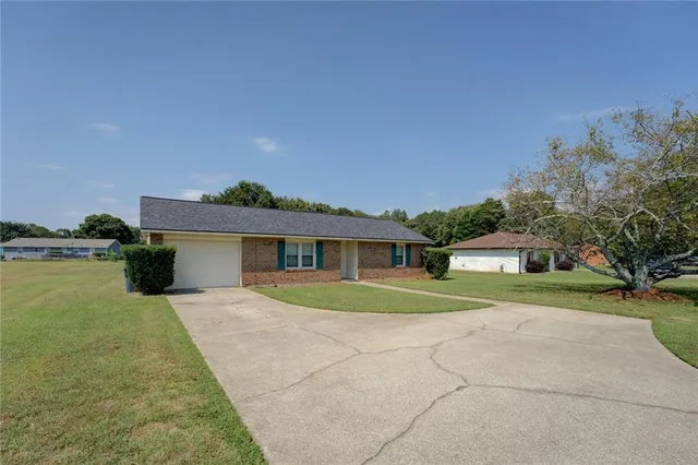 a front view of a house with a yard and trees