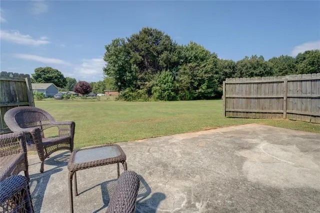 a view of a backyard with lawn chairs potted plants and a palm tree