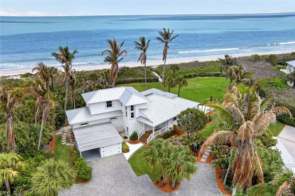 an aerial view of a house with garden space and ocean view