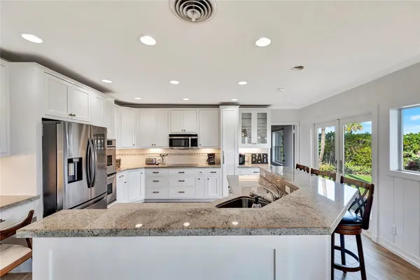 a kitchen with granite countertop white cabinets and white appliances