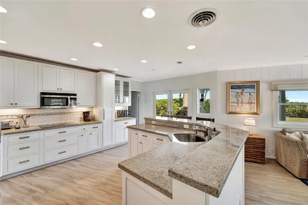 a kitchen with granite countertop a refrigerator and a sink