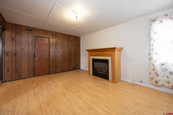 a view of a hallway with stainless steel appliances granite countertop lots of cabinets and wooden floor