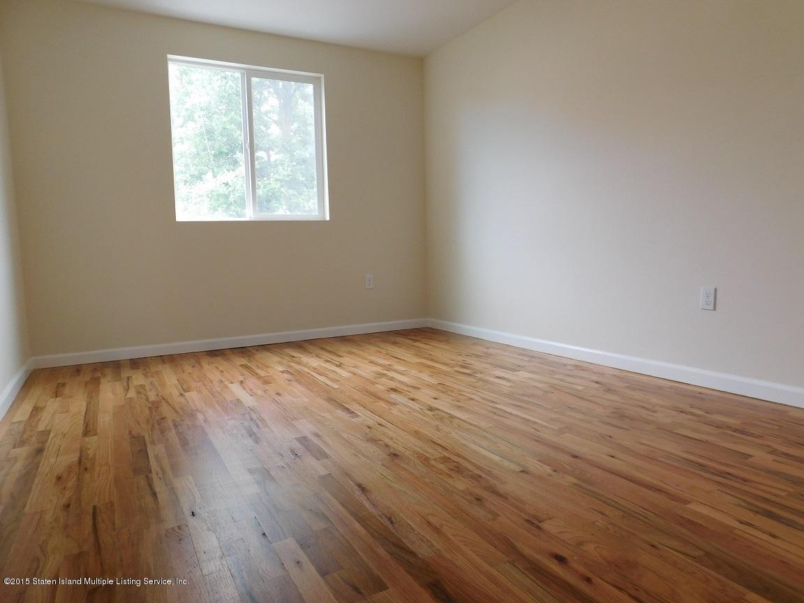 104 Willowbrook Road Staten Island, NY 10302 - Photo 11 of 16 a view of an empty room with wooden floor and a window