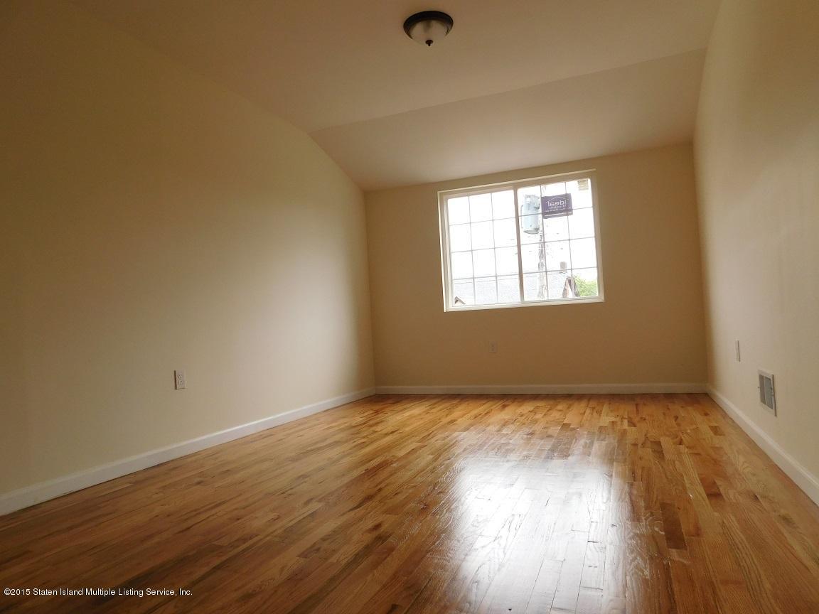104 Willowbrook Road Staten Island, NY 10302 - Photo 14 of 16 a view of an empty room with wooden floor and a window