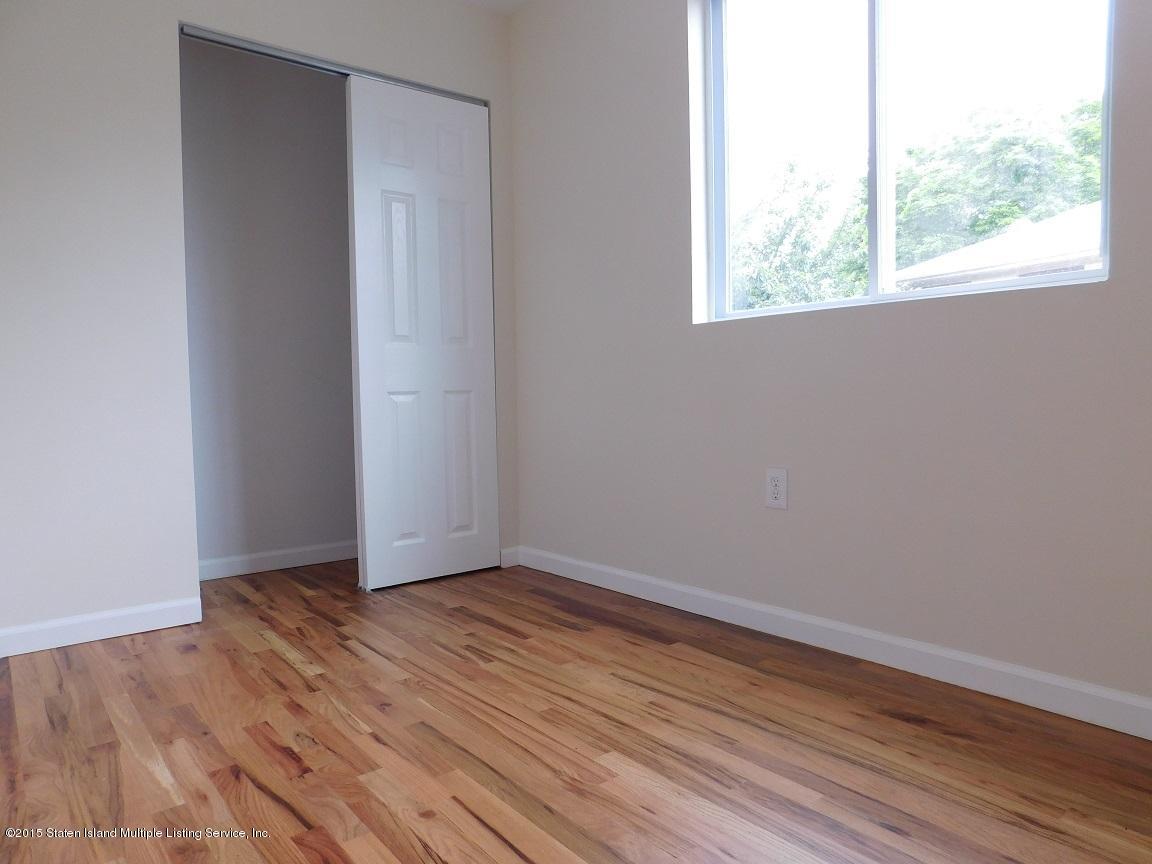 104 Willowbrook Road Staten Island, NY 10302 - Photo 10 of 16 an empty room with wooden floor and windows