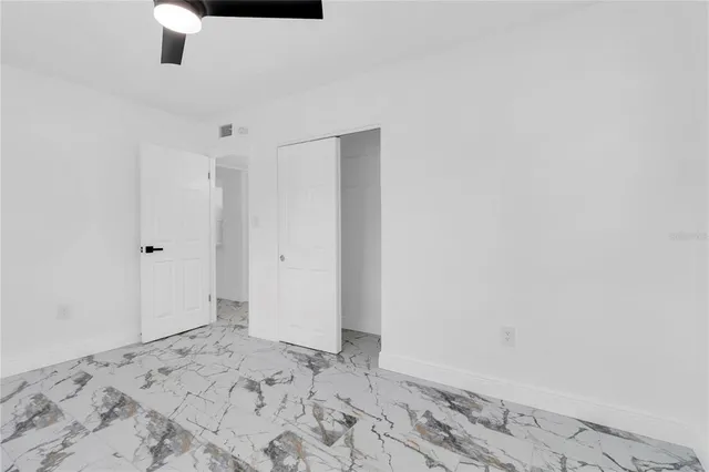 a view of a big room with wooden floor and a chandelier fan