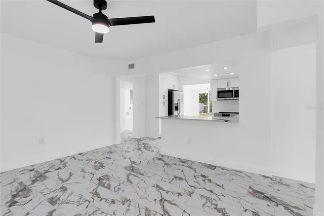 a view of a big room with wooden floor and a window