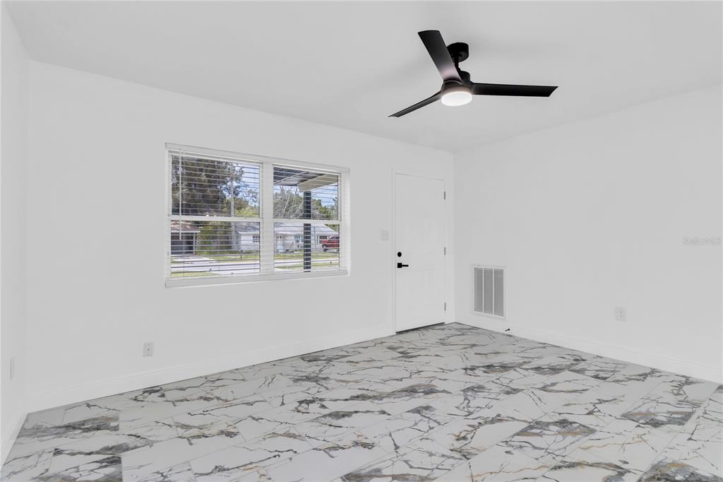 7320 Oelsner Street New Port Richey, FL 34652 - Photo 7 of 29 a view of a big room with wooden floor and a window