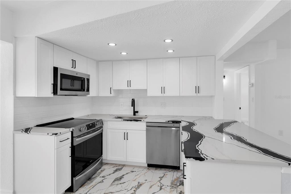7320 Oelsner Street New Port Richey, FL 34652 - Photo 9 of 29 a kitchen with a sink stove top oven and cabinets