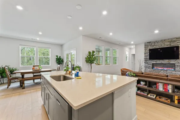 a kitchen with stainless steel appliances a table and chairs in it