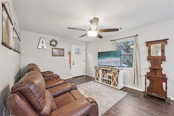 a living room with furniture kitchen view and a chandelier