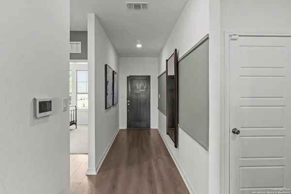 a view of a hallway with wooden floor and closet area