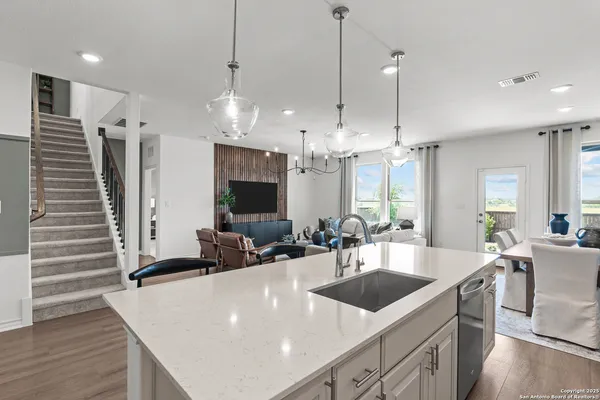 a kitchen with stainless steel appliances a sink a counter top space a large window and furniture