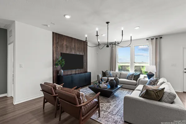 a living room with furniture wooden floor and a flat screen tv