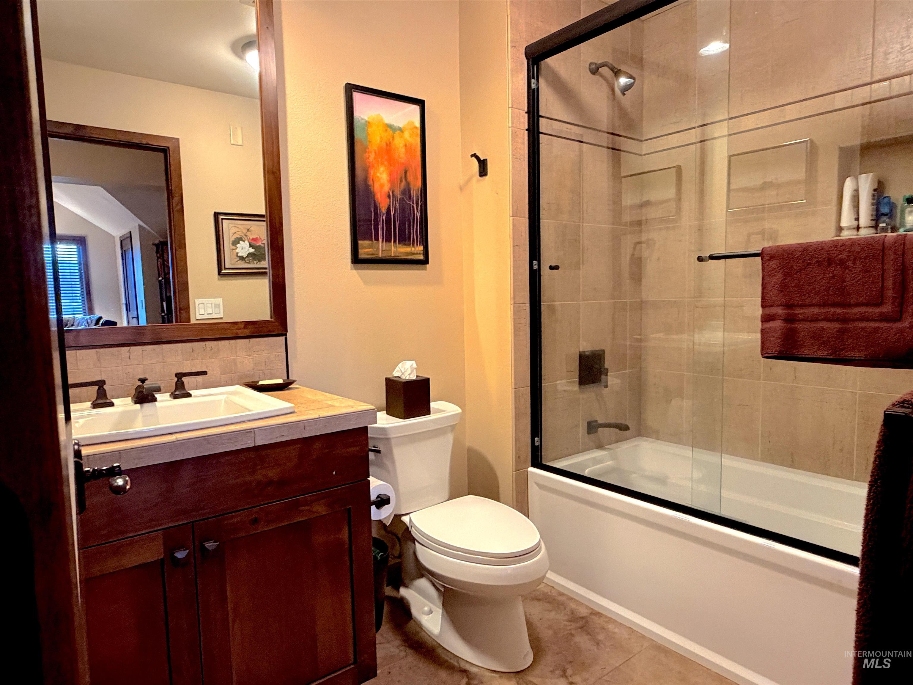 616 North 3rd Street, Unit 211 McCall, ID 83638 - Photo 33 of 49 Full bathroom with vanity, shower / bath combination with glass door, backsplash, and light tile patterned flooring