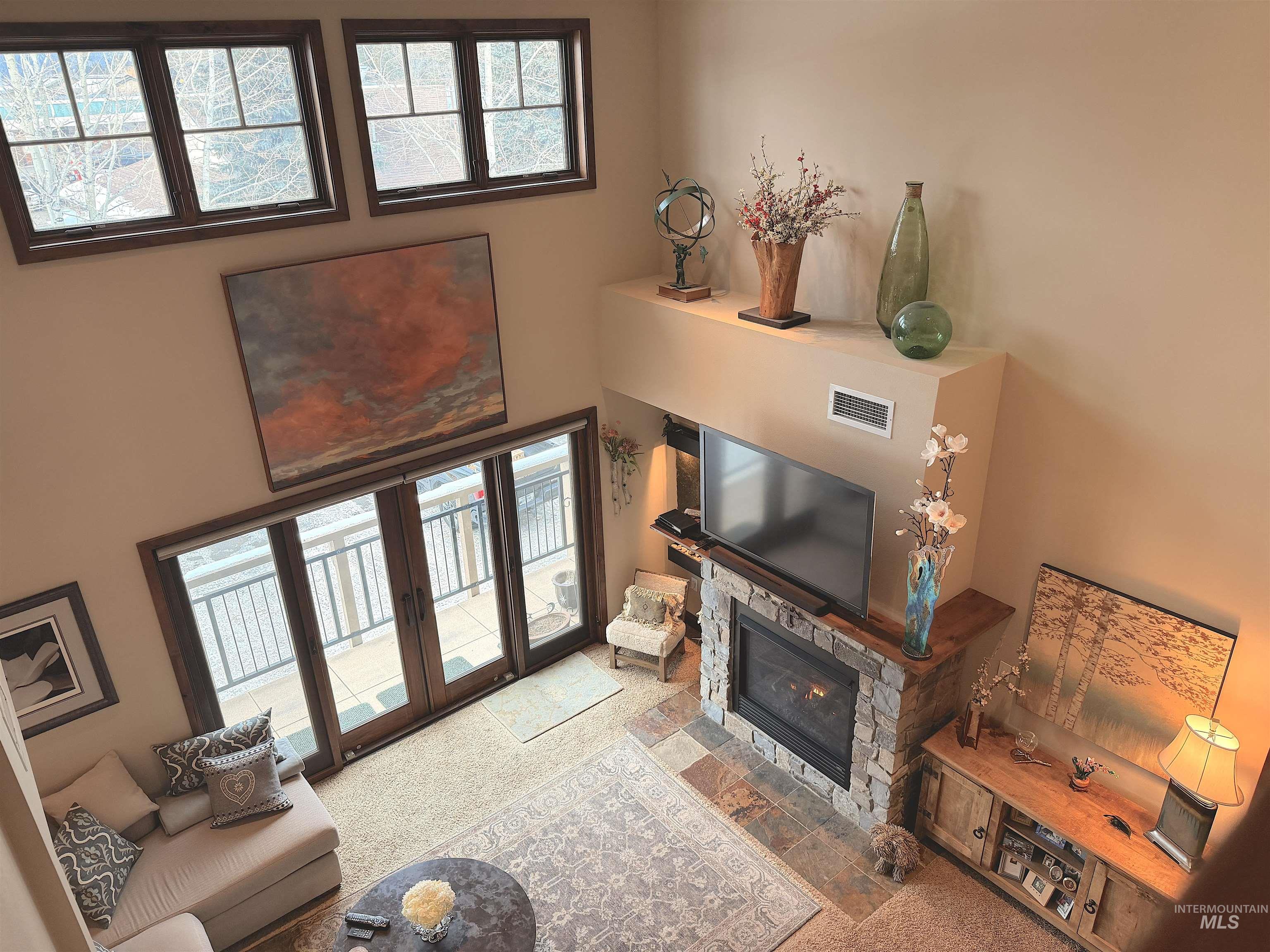 616 North 3rd Street, Unit 211 McCall, ID 83638 - Photo 9 of 49 Carpeted living area with plenty of natural light, a fireplace, and a towering ceiling