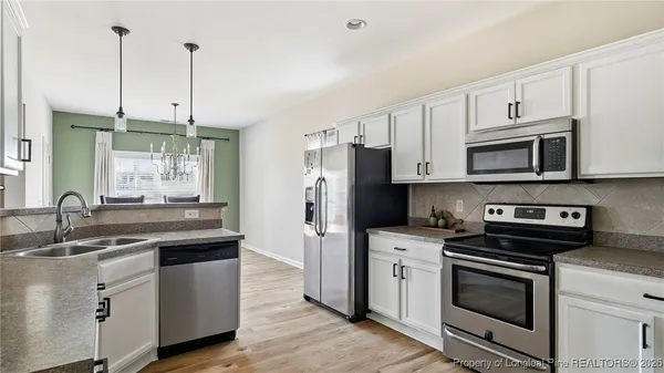 a kitchen with stainless steel appliances granite countertop a sink stove a refrigerator and a granite counter tops
