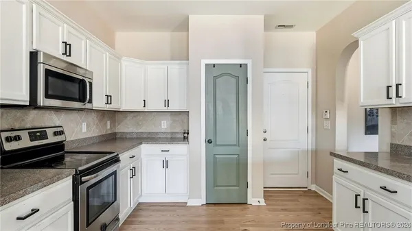 a kitchen with stainless steel appliances granite countertop a refrigerator and a stove top oven
