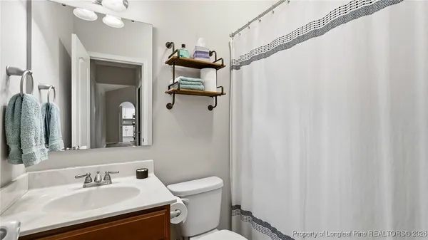 a bathroom with a sink vanity mirror and toilet