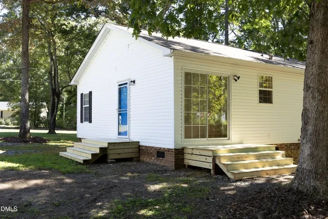 a view of a house with backyard and sitting area