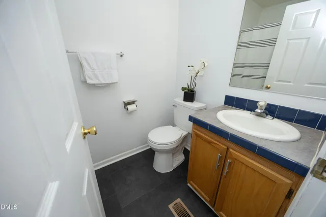 a bathroom with a granite countertop toilet sink and mirror