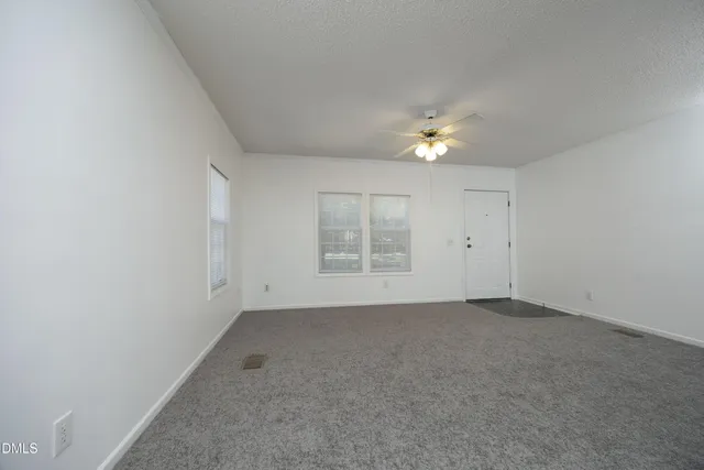 an empty room with fan and window