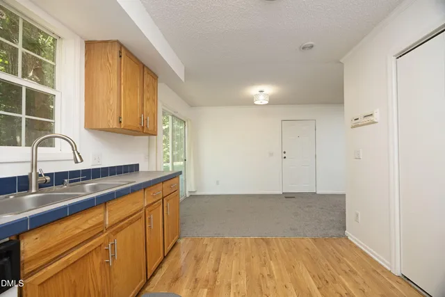 a kitchen with granite countertop wooden cabinets and sink